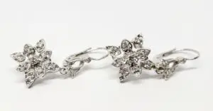 Silver flower-shaped earrings with gemstones.