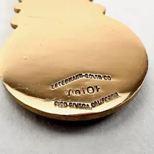 Gold ornament with engraved text underneath.