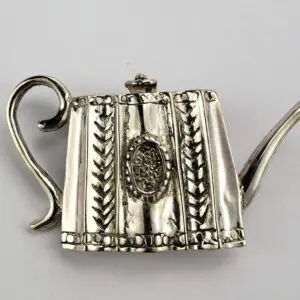 Ornate silver teapot brooch with handle.