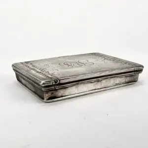 Engraved silver box with decorative patterns.