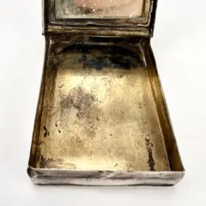 Open vintage metal compact with mirror.
