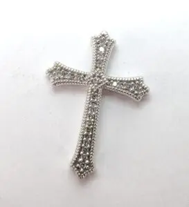 Silver cross with intricate beaded design.