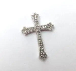 Decorative silver cross with intricate details.