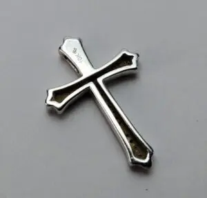 Silver cross pendant on white background.