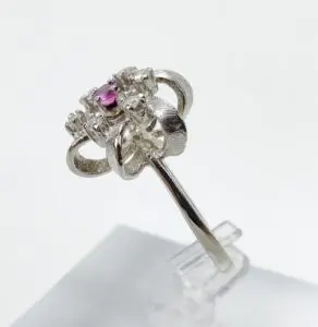 Silver ring with pink gemstone, intricate design.