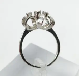 Silver ring with multiple loops and prongs.