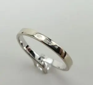 Silver ring with engraved hallmarks on band.