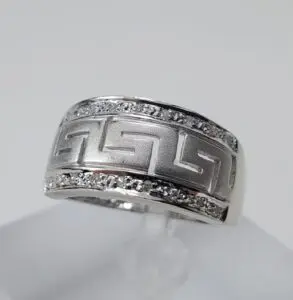 Silver ring with geometric pattern and stones.