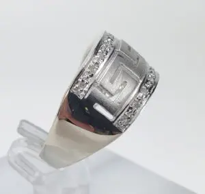 Silver ring with geometric design and diamonds.