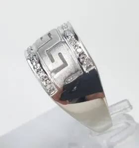 Silver ring with geometric pattern and diamonds.