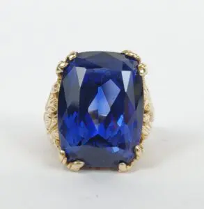 Blue gemstone ring with ornate gold setting.
