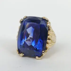 Gold ring with large blue gemstone.