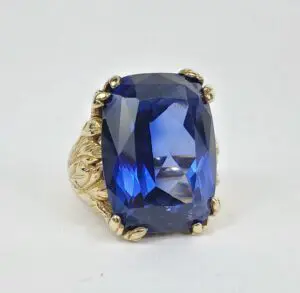 Gold ring with large blue gemstone.