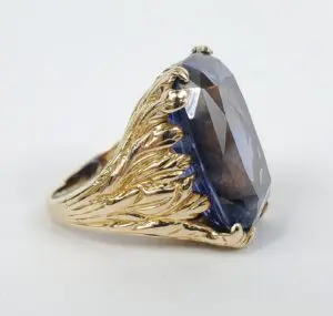 Gold ring with large blue gemstone.