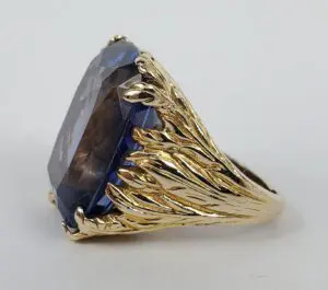 Gold ring with large blue gemstone.