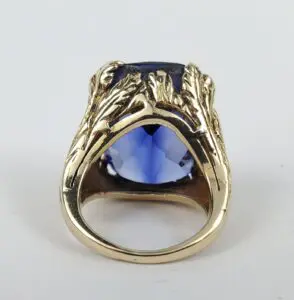 Gold ring with large blue gemstone.