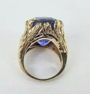 Gold ring with large blue gemstone.
