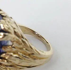 Gold ring with intricate design and gemstone.