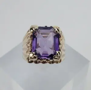 Gold ring with a purple gemstone.