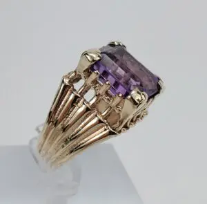 Gold ring with large purple gemstone.