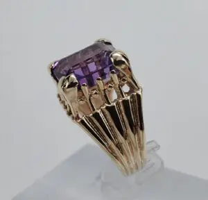 Gold ring with large purple gemstone.
