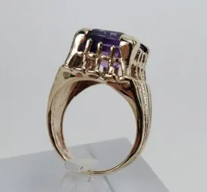 Gold ring with a purple gemstone.