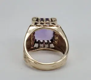 Gold ring with purple gemstone, back view.