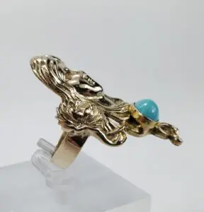 Gold ring with turquoise gemstone design.