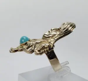 Gold ring with turquoise stone on display.