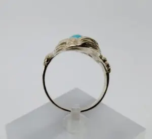 Gold ring with turquoise stone display.