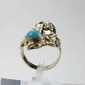 Gold ring with turquoise cabochon stone.
