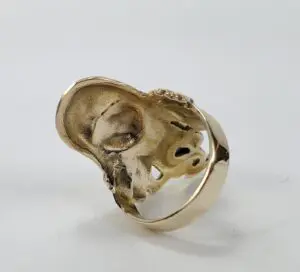 Gold ring featuring a sculpted skull design.