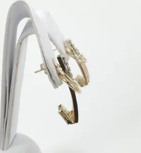 Gold hoop earrings on display stand.