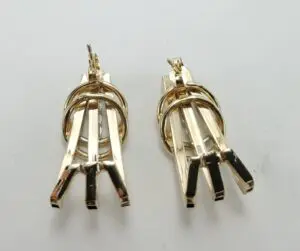 Gold geometric dangle earrings on display.