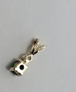 Silver pendant with green gemstone on white.