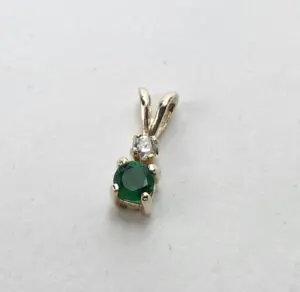 Gold pendant with emerald and diamond gemstones.