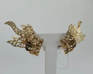 Gold dragon-shaped earrings on display stand.