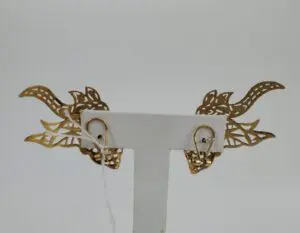Intricate dragon-themed gold earrings display.