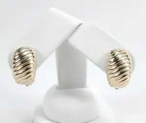 Gold ribbed clip-on earrings on display.