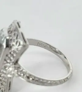 Close-up of 18K engraved silver ring.