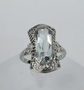 Ornate silver ring with clear gemstone.
