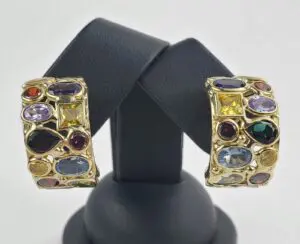 Gold earrings with colorful gemstones on display.