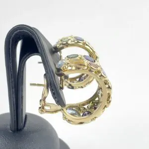 Gold hoop earrings with colorful gemstones.