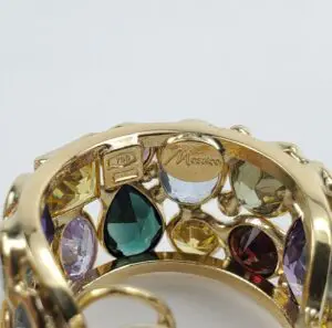 Gold ring with colorful gemstones and engravings.