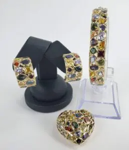Colorful gemstone jewelry set on display stands.