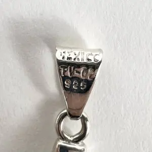 Silver pendant bail with engraved markings.