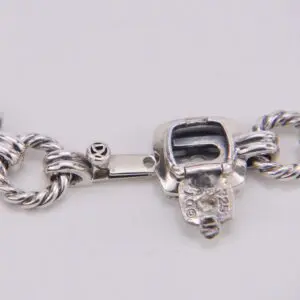 Silver bracelet clasp with intricate design.