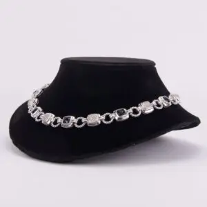Silver bracelet displayed on black velvet stand.