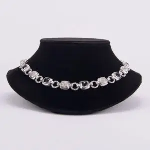 Silver bracelet displayed on black velvet stand.