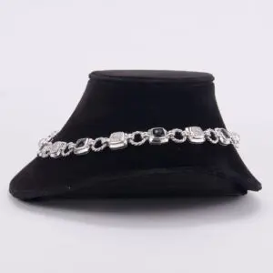 Silver bracelet on black velvet display.